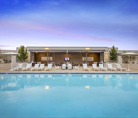 Swimming pool with cabana and seating at twilight at Casa Mira View Apartments, San Diego