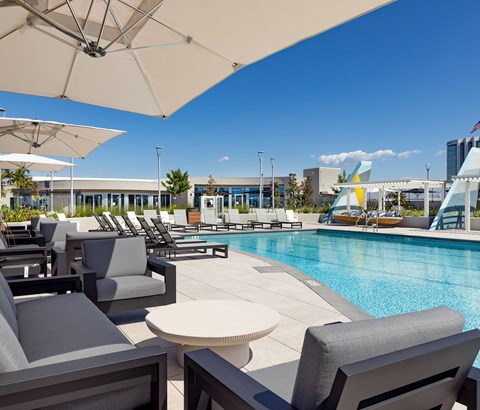 A pool area with lounge chairs and umbrellas.