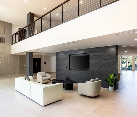 A modern living room with a white sofa and a black TV.