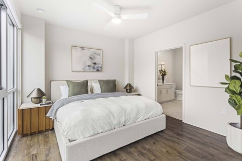 A bedroom with a large bed and a ceiling fan.