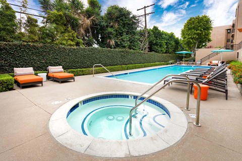 A small pool with a hot tub in the middle of it.