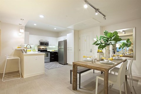 A modern kitchen with a dining table set for two.