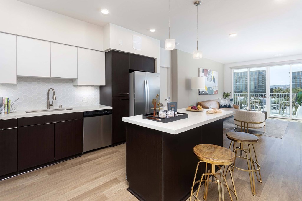 A modern kitchen with dark brown cabinets and a white island.