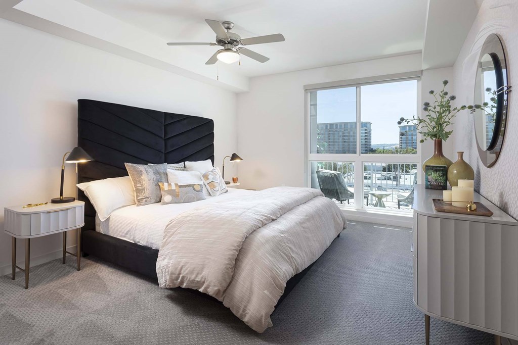 A bedroom with a large bed and a ceiling fan.