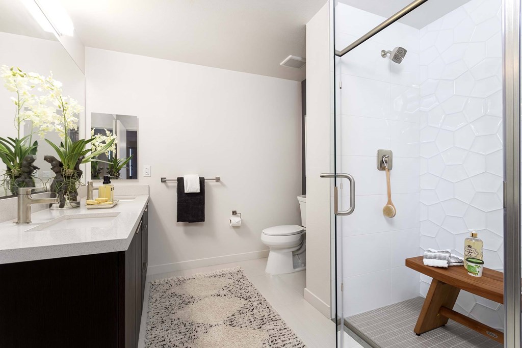A bathroom with a toilet, sink, and shower.