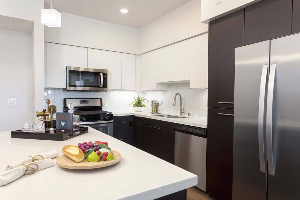 A modern kitchen with a wooden cutting board on the counter.
