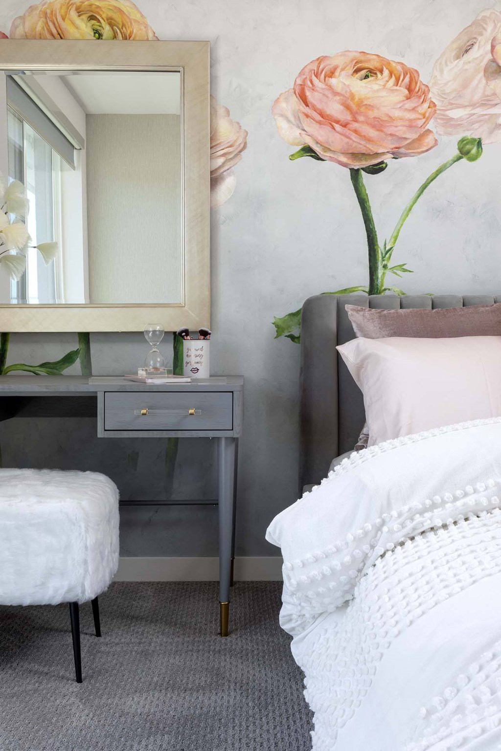 A white chair sits in front of a desk with a mirror above it.