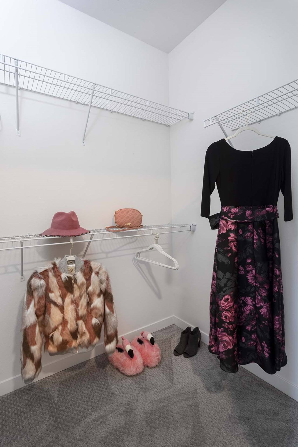 A black top and floral skirt are displayed on a hanger in a white closet.