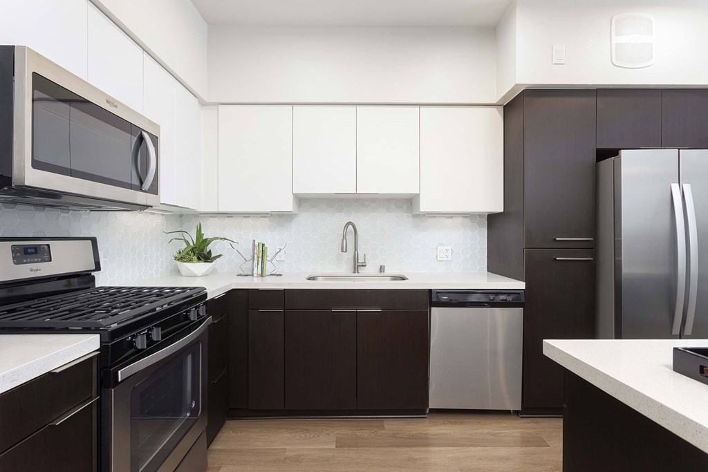 A modern kitchen with dark brown cabinets and stainless steel appliances.