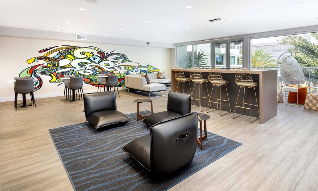 A room with a large mural on the wall and several chairs and tables.