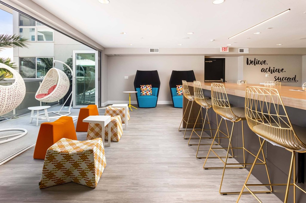 A room with a long table and chairs and a sign on the wall that says "believe achieve succeed".