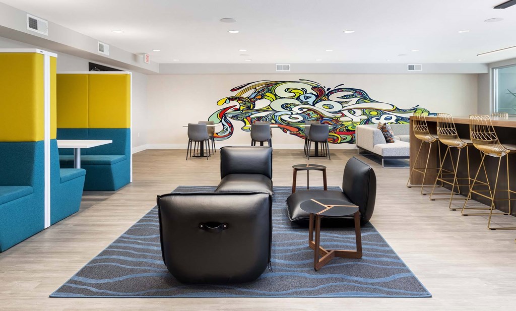 A room with a large mural and a variety of seating options.