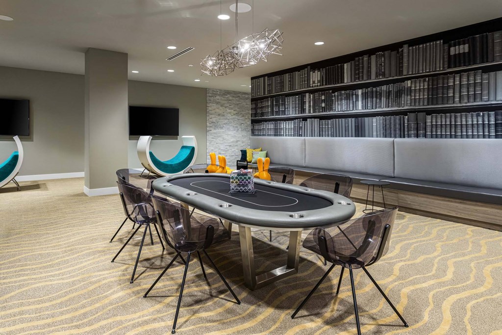 A room with a poker table and chairs.