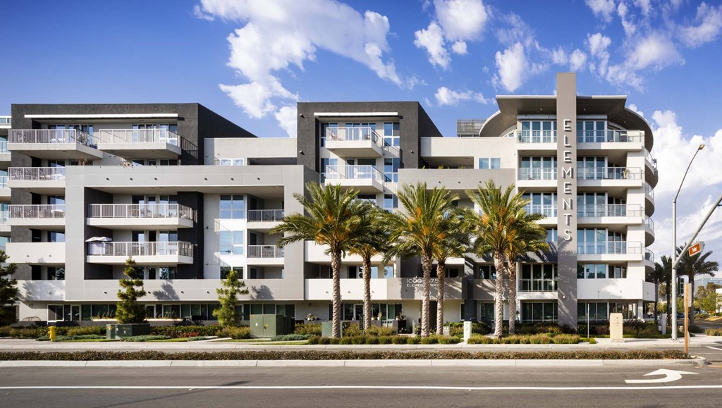 A modern building with palm trees in front.