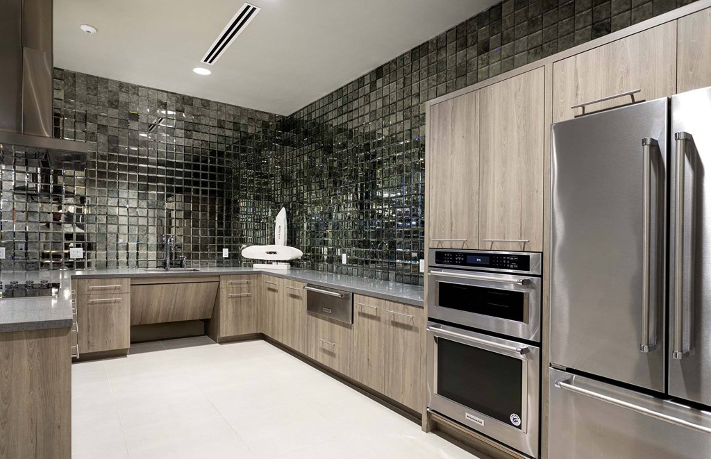 A modern kitchen with a stainless steel refrigerator and oven.