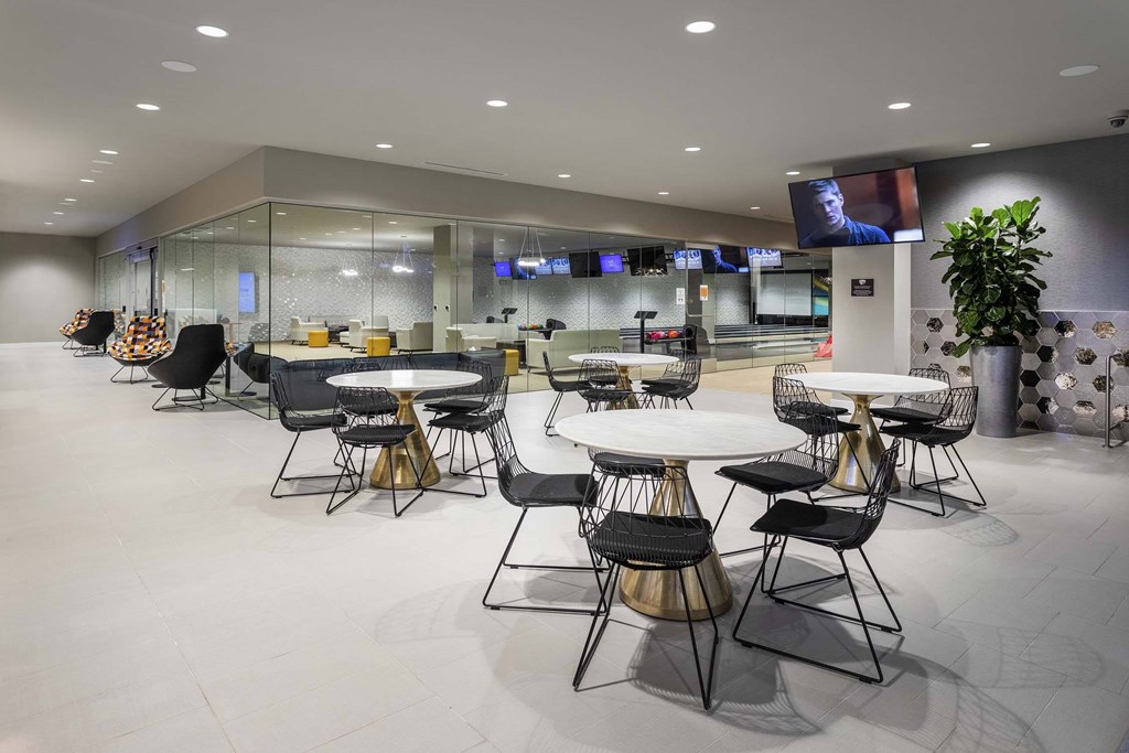 A modern conference room with a glass wall and a TV screen.