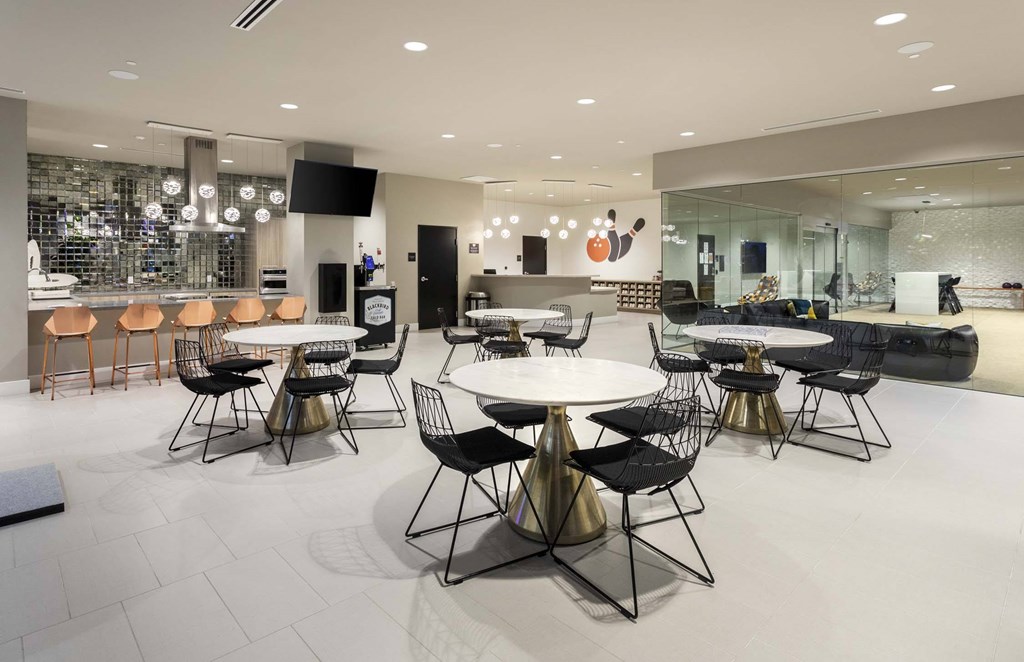 A modern dining room with a glass wall and a bar area.