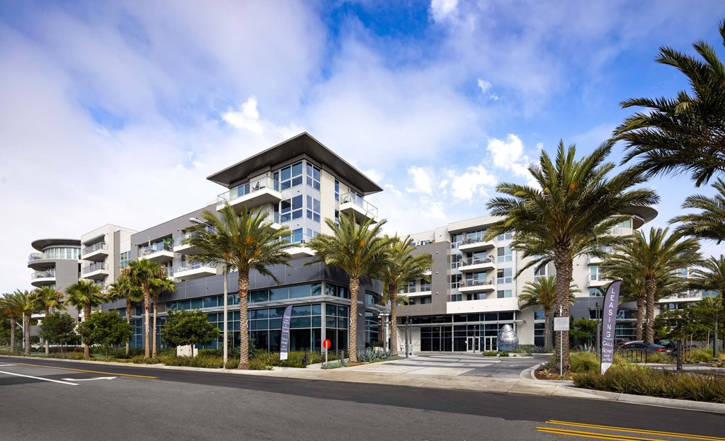 A modern building with palm trees in front.