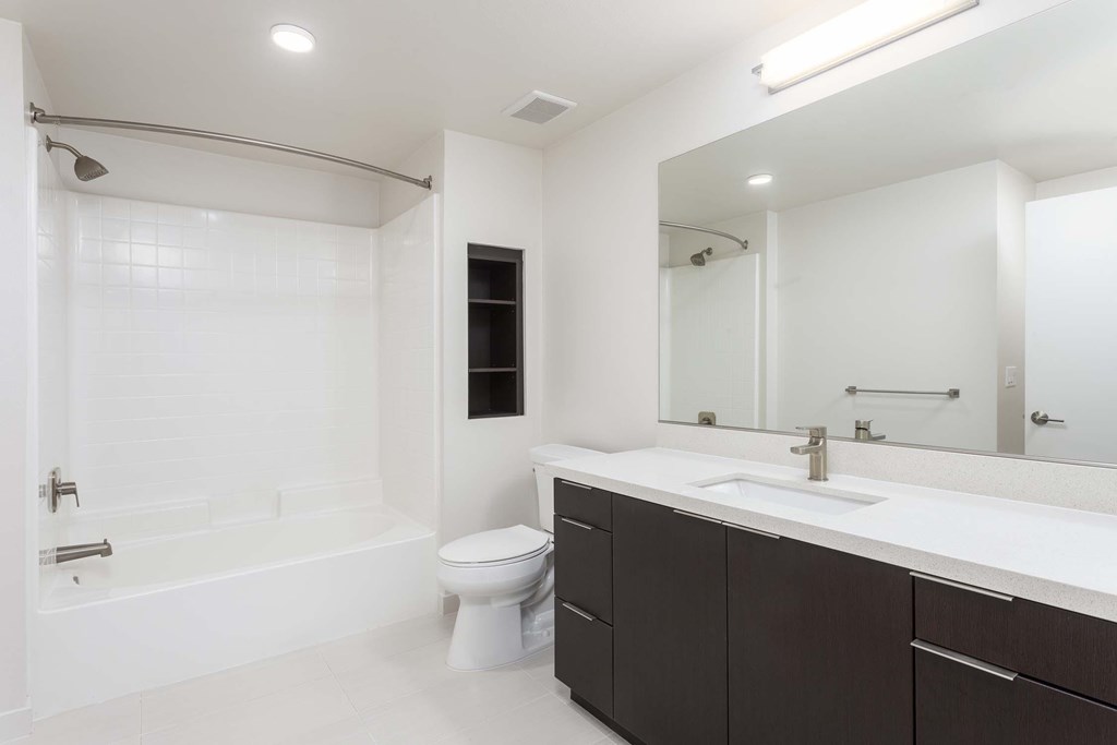 A white bathroom with a toilet, sink, and bathtub.