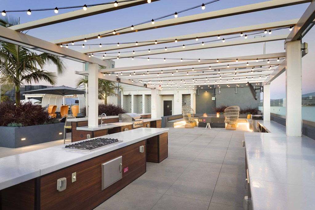 A modern outdoor kitchen with a bar area and seating.