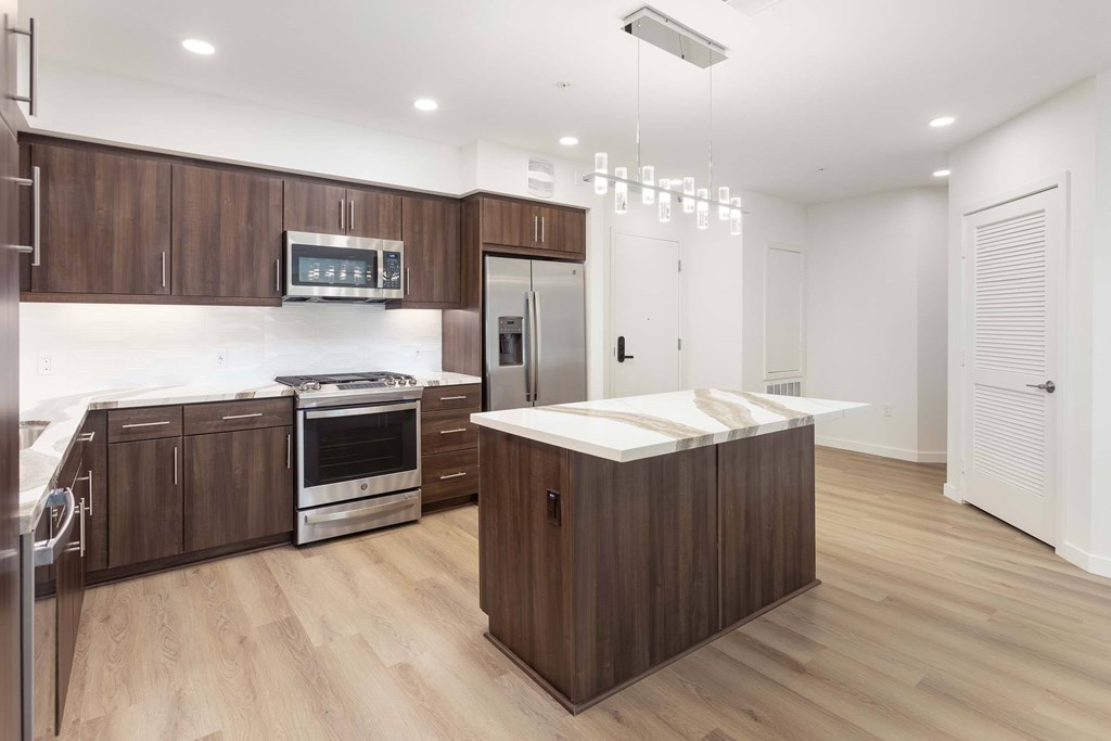 A modern kitchen with wooden cabinets and stainless steel appliances.