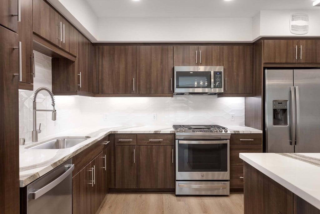 A modern kitchen with wooden cabinets and stainless steel appliances.