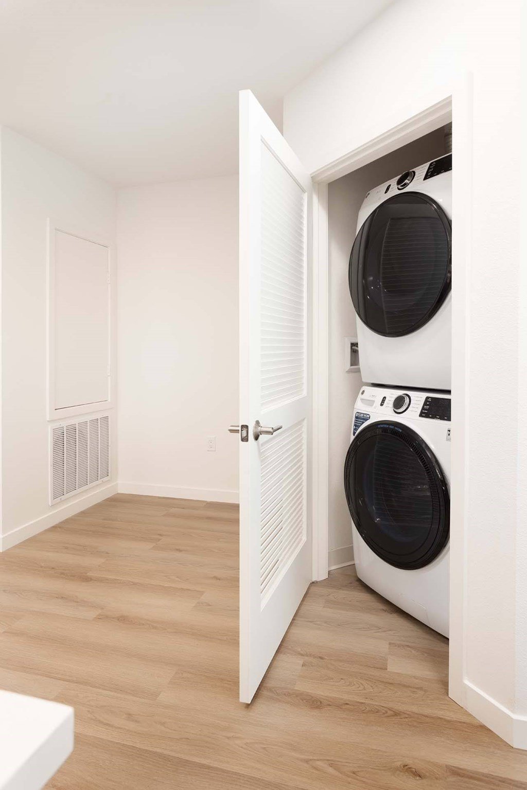 A white washing machine is in a white door.