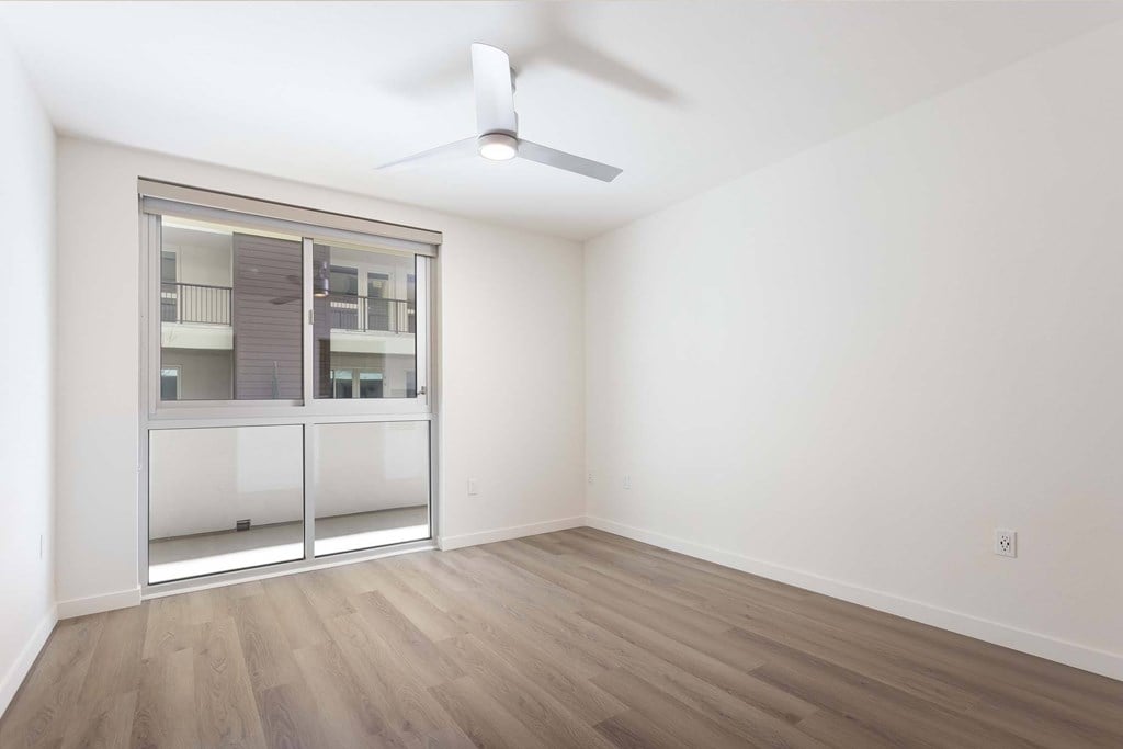 A room with a sliding door and a ceiling fan.