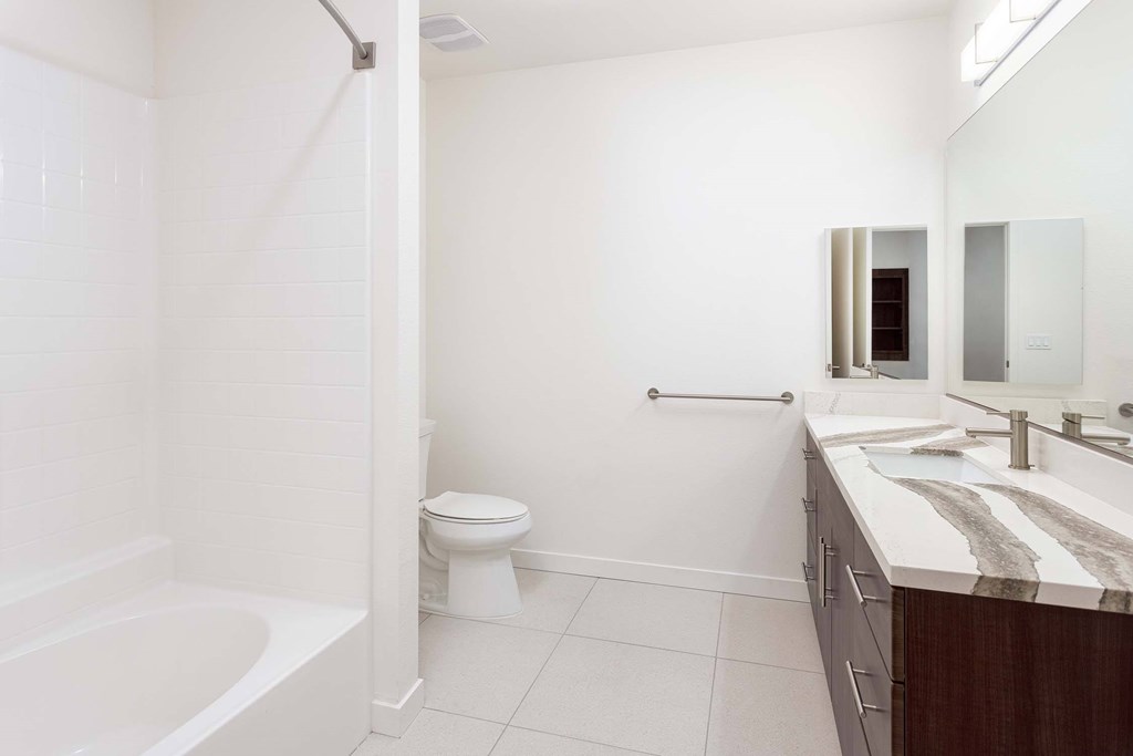 A white bathroom with a toilet, sink, and bathtub.