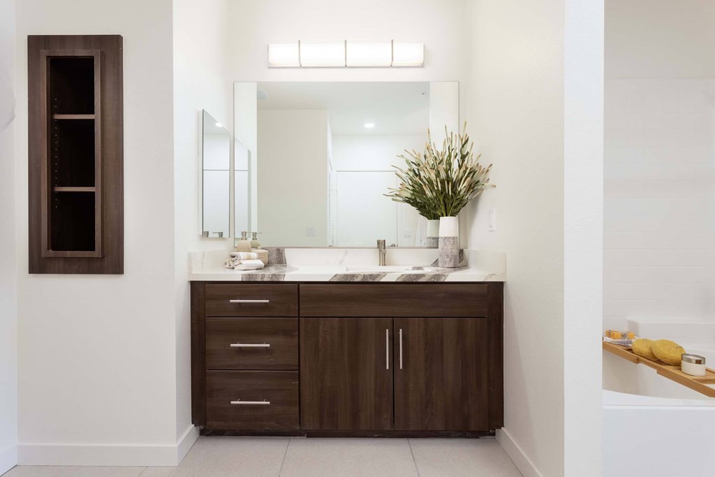 A bathroom with a brown cabinet and a white sink.