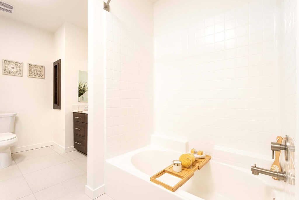 A white bathroom with a tub and a toilet.