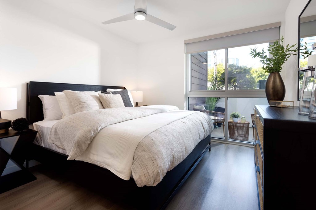 A bedroom with a large bed and a ceiling fan.