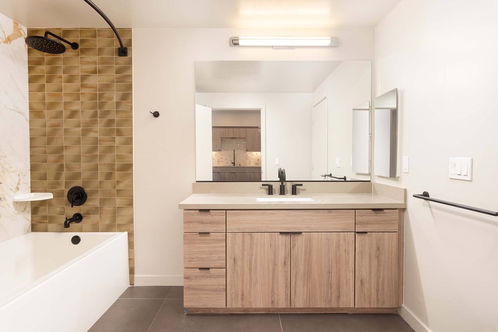 A bathroom with a shower, sink, and mirror.