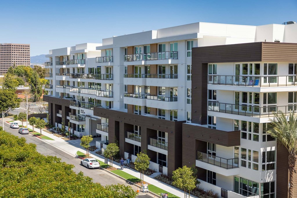 A modern apartment building with balconies and multiple floors.