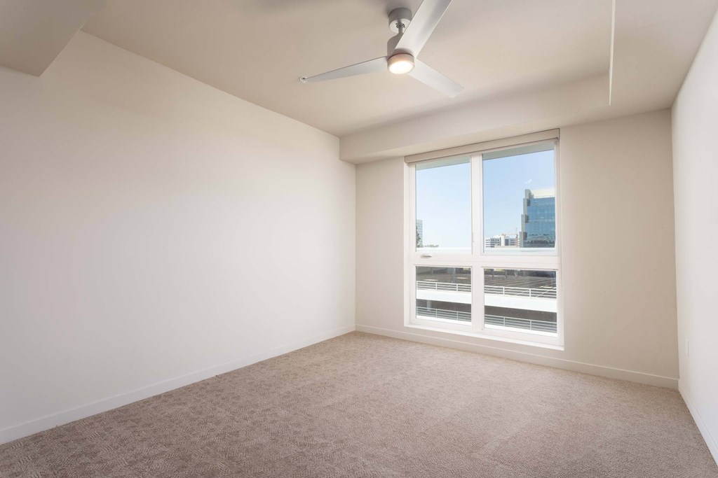 A room with a window and a ceiling fan.