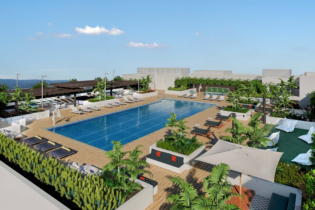 A large outdoor swimming pool surrounded by lounge chairs and greenery.