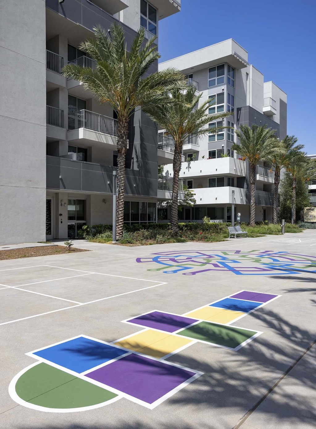 A multi-story building with a bicycle painted on the ground in front of it.