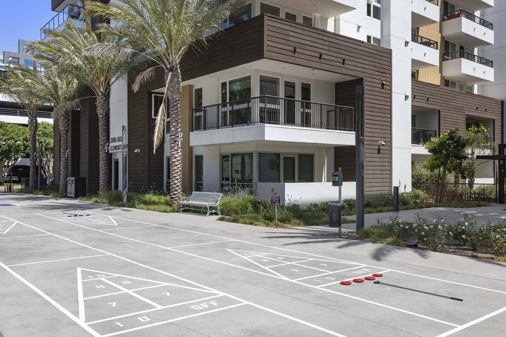 A parking lot with numbered parking spaces in front of a building.