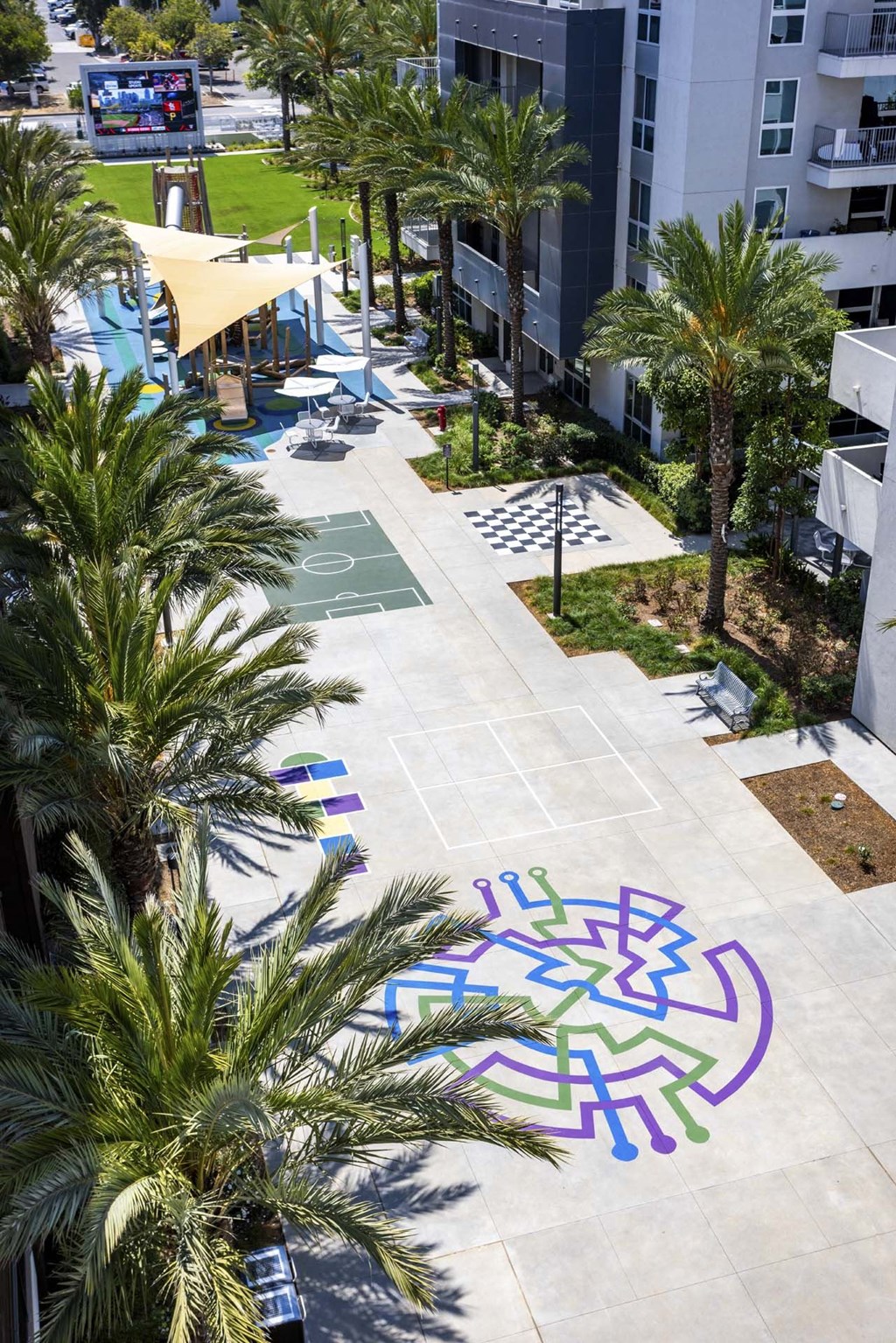 A labyrinth is painted on the pavement of a courtyard.