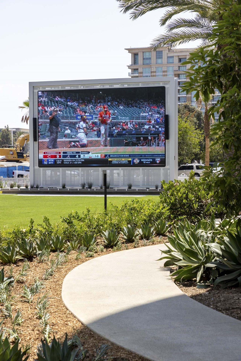 A large outdoor television screen is displaying a baseball game.