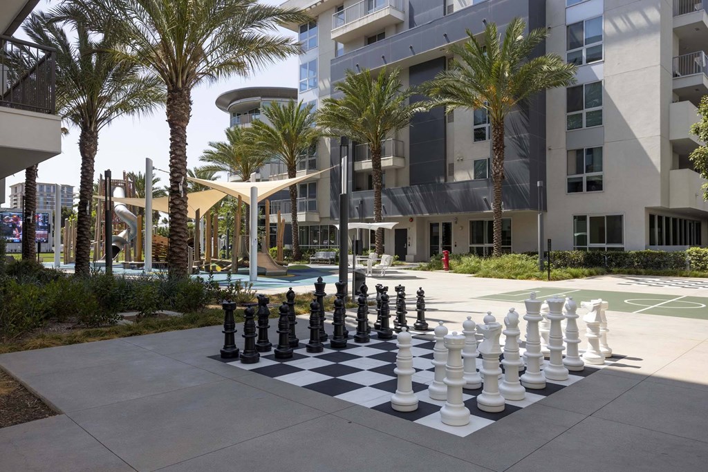 A giant chess set is in the middle of a courtyard.