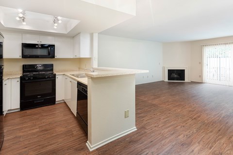 A kitchen with black appliances and white cabinets.