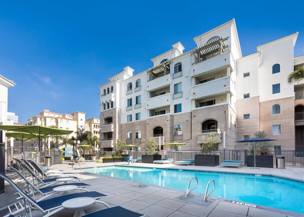 A large white building with a pool in front. at La Jolla Crossroads Apartments, San Diego
