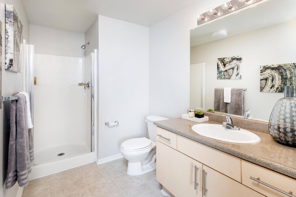 A bathroom with a toilet, sink, and mirror. at La Jolla Crossroads Apartments, San Diego, CA, 92122