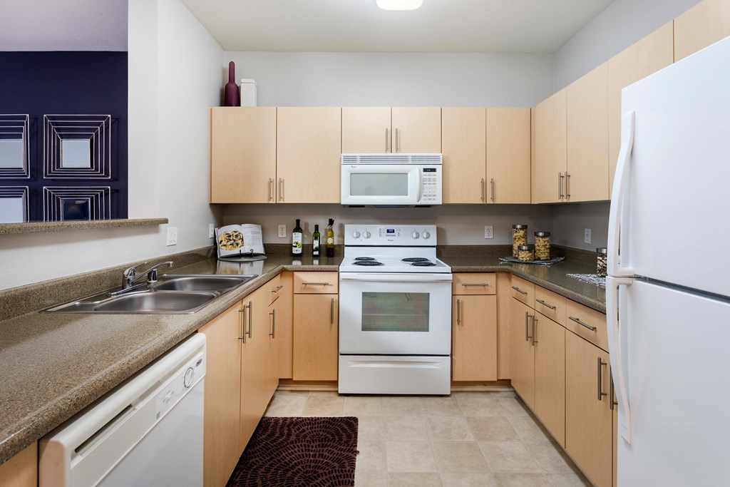 A kitchen with a white oven and refrigerator. at La Jolla Crossroads Apartments, San Diego