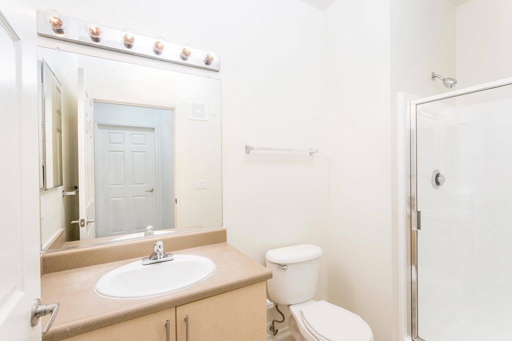A bathroom with a sink, toilet, and shower. at La Jolla Crossroads Apartments, San Diego