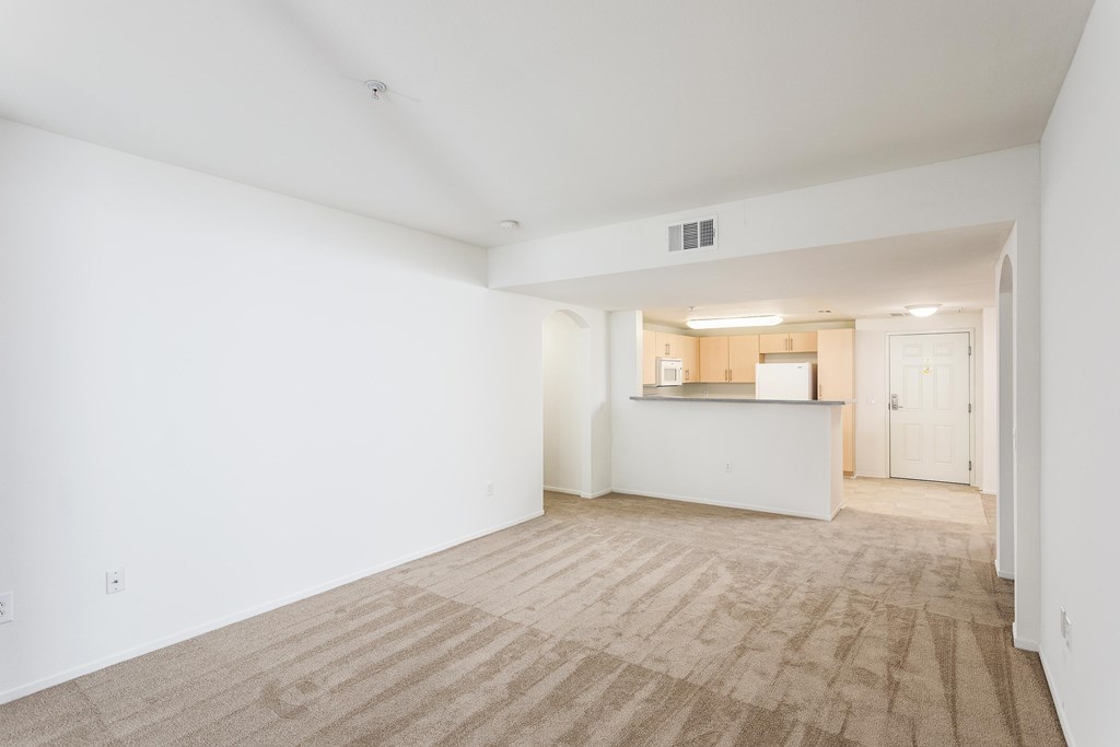 A large empty room with a carpeted floor and white walls. at La Jolla Crossroads Apartments, California