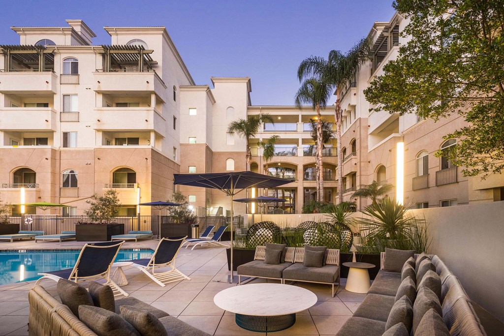 A large building with a pool and lounge chairs. at La Jolla Crossroads Apartments, California, 92122