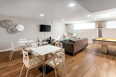 A modern dining room with a white table and chairs.