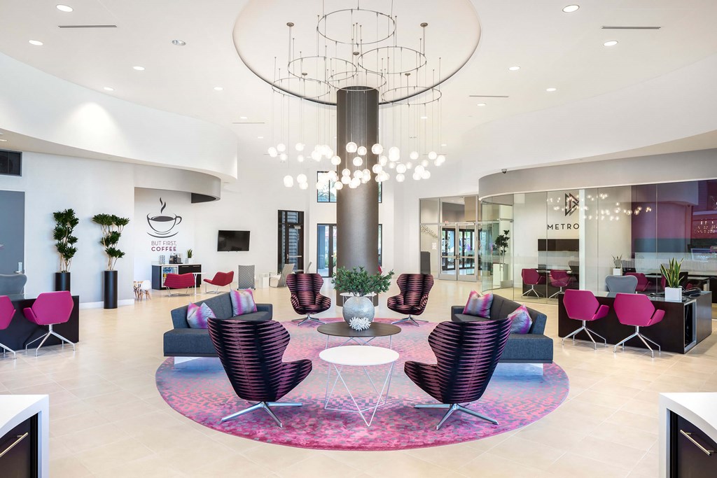 A large, modern room with a circular table in the center and chairs surrounding it.